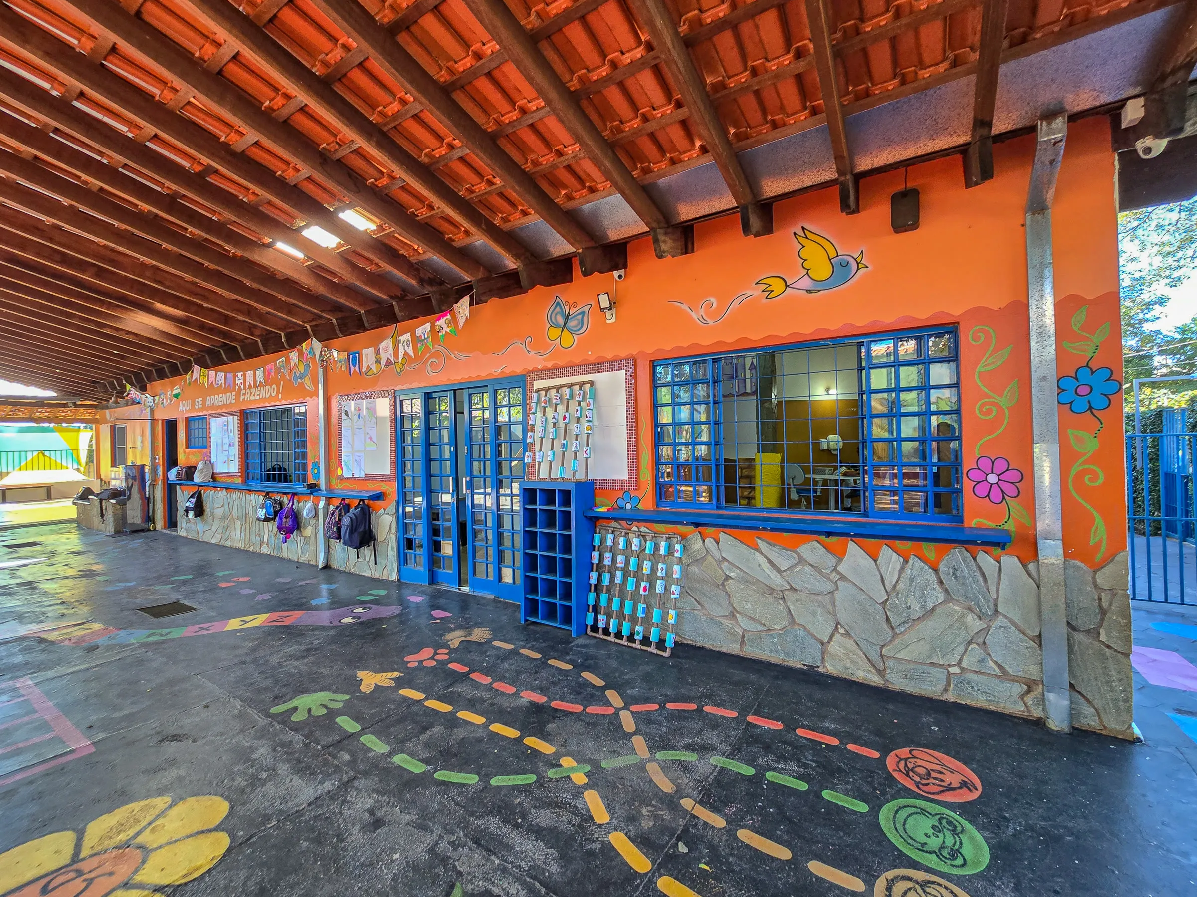 Varanda das salas da Te Apoio, com paredes pintadas e amarelinha no chão