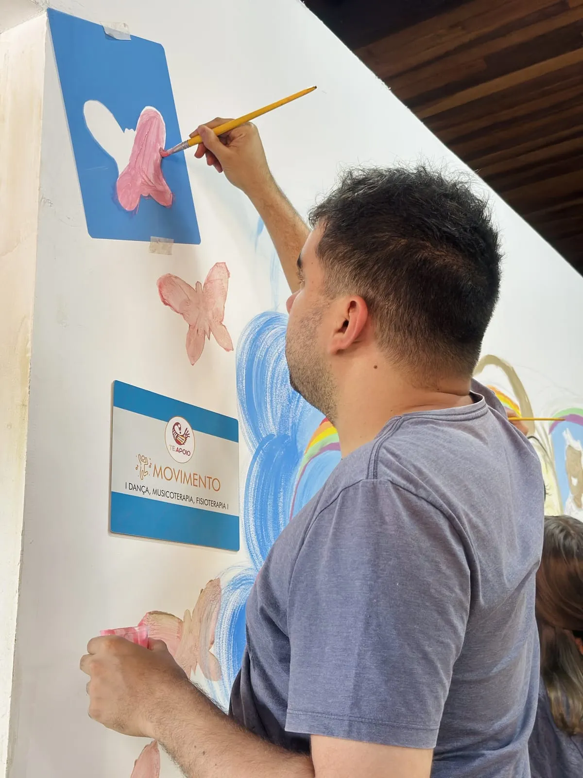 Participante pintando uma borboleta com molde de estêncil